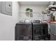Functional laundry room with modern washer and dryer, white walls, and checkered floors at 904 Ivy Green Se Ln, Marietta, GA 30067