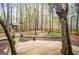 Beautiful backyard features a wooden deck, mature trees and a charming wooden playhouse at 9176 Lakeview Pkwy, Villa Rica, GA 30180