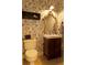 Cozy bathroom features decorative wallpaper, a wooden vanity, and a golden framed mirror at 9176 Lakeview Pkwy, Villa Rica, GA 30180