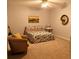 Bedroom with neutral carpet, ceiling fan and comfortable bed with decorative pillows and armchair at 9176 Lakeview Pkwy, Villa Rica, GA 30180