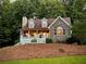 Charming home with stone facade, dormer windows, and a cozy front porch nestled among mature trees at 9176 Lakeview Pkwy, Villa Rica, GA 30180
