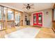 Inviting screened porch with wooden floors, red double doors, ceiling fan and stylish outdoor rug at 9176 Lakeview Pkwy, Villa Rica, GA 30180