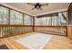 Screened porch features a ceiling fan, wood floors and view to the backyard with mature trees at 9176 Lakeview Pkwy, Villa Rica, GA 30180