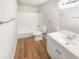 Clean bathroom featuring wood-look floors, a shower-tub combo, and a white single sink vanity at 6354 Shannon Pkwy # 8B, Union City, GA 30291