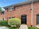 Brick townhouse exterior with dark door, red shutters and green landscaping at 6354 Shannon Pkwy # 8B, Union City, GA 30291