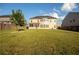 Extensive backyard with lush green grass, wood fence, and a view of the home at 905 Eldridge Rd, Hampton, GA 30228