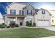 Charming two-story home with a brick facade, a well-manicured lawn and an attached two-car garage at 905 Eldridge Rd, Hampton, GA 30228