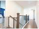 Upstairs hallway featuring hardwood floors, neutral paint, a baby gate and access to multiple rooms at 905 Eldridge Rd, Hampton, GA 30228
