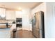 Modern kitchen with stainless steel refrigerator, granite counters, tile backsplash, and white cabinets at 905 Eldridge Rd, Hampton, GA 30228