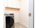 This laundry room has upper cabinets, tile flooring, and a front-load washing machine at 905 Eldridge Rd, Hampton, GA 30228