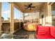 Screened-in patio with a hot tub, ceiling fan, and comfortable red cushioned couch at 905 Eldridge Rd, Hampton, GA 30228