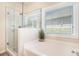 Modern bathroom featuring a glass enclosed shower, a garden tub, and neutral paint at 1856 Temple Park Dr, Loganville, GA 30052