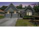 Beautiful home exterior featuring a stone facade, two-car garage, and manicured lawn at 1856 Temple Park Dr, Loganville, GA 30052