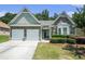 Well-kept home featuring a stone facade, two-car garage, manicured lawn, and bay window at 1856 Temple Park Dr, Loganville, GA 30052