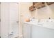 Clean laundry room with modern washer, dryer, and convenient overhead shelving at 1856 Temple Park Dr, Loganville, GA 30052