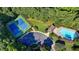 Aerial view showcasing community tennis courts, a pool, and parking, all nestled in a lush wooded setting at 2035 Lena Carter Rd, Buford, GA 30519