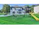 This backyard features a white house with a concrete patio with a playground at 2035 Lena Carter Rd, Buford, GA 30519
