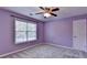 This bedroom has purple walls, a window and a ceiling fan at 2035 Lena Carter Rd, Buford, GA 30519