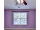 Bedroom features a window, ceiling fan, light purple walls, and neutral carpet at 2035 Lena Carter Rd, Buford, GA 30519
