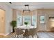 Bright dining area with a round table, modern lighting, and views of the backyard through large windows at 2035 Lena Carter Rd, Buford, GA 30519
