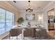 Virtually staged dining room with modern decor, a sleek table, and a view into the updated kitchen at 2035 Lena Carter Rd, Buford, GA 30519