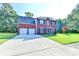 Charming red-brick home with a spacious driveway, lush lawn, and complementary dark blue shutters at 2035 Lena Carter Rd, Buford, GA 30519