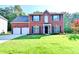 Inviting two-story brick home featuring a well-manicured lawn, two-car garage, and classic dark blue shutters at 2035 Lena Carter Rd, Buford, GA 30519