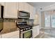 Well-lit kitchen with stainless steel oven and microwave plus white cabinets and granite countertops at 2035 Lena Carter Rd, Buford, GA 30519