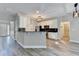 Open-concept kitchen with stainless steel appliances, granite countertops, breakfast bar, and modern lighting fixtures at 2035 Lena Carter Rd, Buford, GA 30519