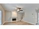 A living room with neutral walls features hardwood floors, a fireplace, and a ceiling fan at 2035 Lena Carter Rd, Buford, GA 30519