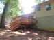 Exterior view of the back of the home with a wooden deck and steps leading down to the backyard at 5512 Arrowhead Dr, Acworth, GA 30102