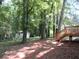 A large backyard with mature trees, a wooden deck, and a storage shed behind a privacy fence at 5512 Arrowhead Dr, Acworth, GA 30102