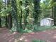 Secluded backyard featuring a storage shed among mature trees covered with beautiful vines at 5512 Arrowhead Dr, Acworth, GA 30102