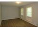 Bright bedroom with wood-look floors, neutral walls, and two large windows at 5512 Arrowhead Dr, Acworth, GA 30102