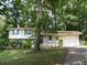 Traditional two-story home with a lush green lawn and mature trees providing shade at 5512 Arrowhead Dr, Acworth, GA 30102