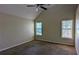 Carpeted main bedroom with two windows and a ceiling fan at 6572 Chestnut Oaks Rdg, Lithonia, GA 30038