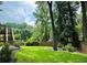 Well-maintained backyard with lush green grass, wooden fence, and mature trees at 735 Jamie Ne Way, Woodstock, GA 30188