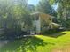 Rear view of home with spacious lawn and mature trees and an outdoor patio area at 975 Willeo Rd, Roswell, GA 30075