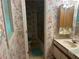 Cozy bathroom with floral wallpaper, shower, and single sink vanity at 975 Willeo Rd, Roswell, GA 30075