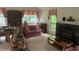 Cozy living room features a fireplace, piano, and large windows at 975 Willeo Rd, Roswell, GA 30075