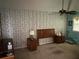 Main bedroom with patterned wallpaper, ceiling fan, and wood furnishings at 975 Willeo Rd, Roswell, GA 30075