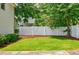 Well-manicured backyard featuring lush green grass, a privacy fence, and shade trees at 1505 Walker Ave, College Park, GA 30337