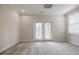 Bright bedroom with neutral walls, plush carpet, and double doors leading to a balcony for outdoor enjoyment at 1505 Walker Ave, College Park, GA 30337