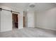 Spacious bedroom featuring plush carpet, a ceiling fan, and a barn door leading to the ensuite bathroom at 1505 Walker Ave, College Park, GA 30337