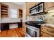 Well-lit kitchen showcases stainless steel oven and microwave, light brown cabinetry, and stylish countertops at 1505 Walker Ave, College Park, GA 30337