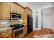 Bright kitchen features stainless steel oven and microwave, beautiful tile backsplash, and hardwood floors at 1505 Walker Ave, College Park, GA 30337