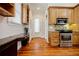 Open kitchen with stainless steel appliances, custom cabinets, built-in desk area, and rich hardwood floors at 1505 Walker Ave, College Park, GA 30337