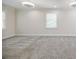 Open living room area featuring plush gray carpeting, neutral colors, and abundant natural light at 1505 Walker Ave, College Park, GA 30337