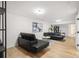Finished basement area with black leather furniture and light hardwood flooring at 3388 Hyland Dr, Decatur, GA 30032