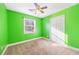 A bright green bedroom with carpet, a ceiling fan, and a window letting in natural light at 1035 Stonewall Se Dr, Atlanta, GA 30315